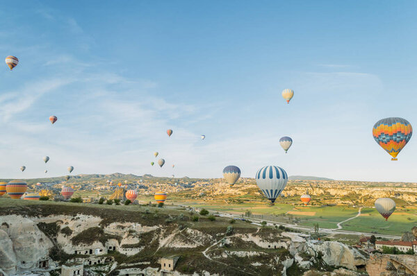 front view of colorful hot air balloons flying over city in Cappadocia, Turkey