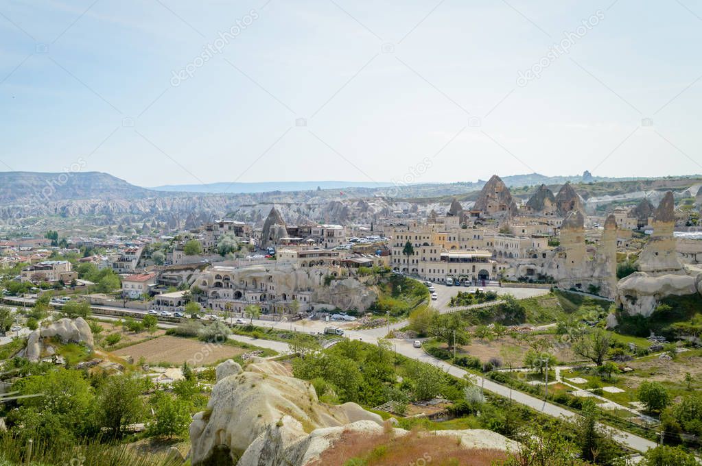 aerial view of cityscape and stone formations under cloudy blue sky, Cappadocia, Turkey