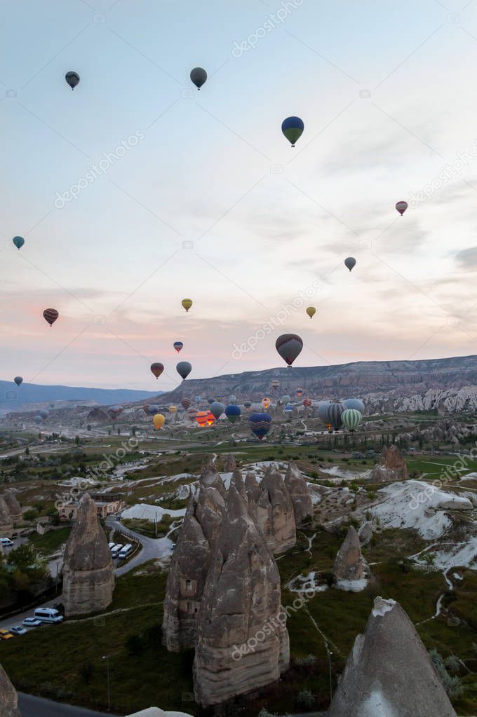 front view of hot air balloons flying over stone formations, Cappadocia, Turkey