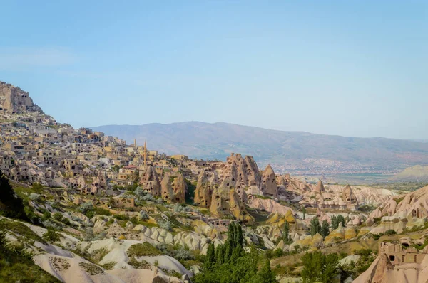 Veduta aerea del paesaggio urbano e delle montagne sotto il cielo blu senza nuvole in Cappadocia, Turchia — Foto stock