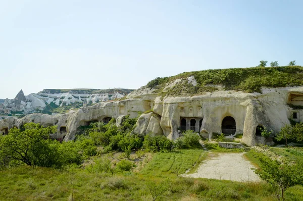 Antigas habitações de cavernas em vale sob céu azul, Capadócia, Turquia — Fotografia de Stock