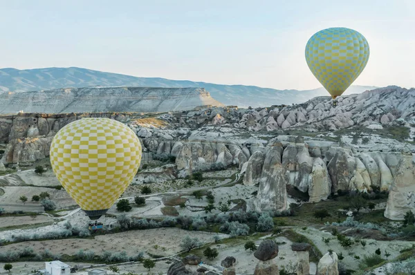 Vue de face de deux montgolfières survolant des formations rocheuses dans la vallée de Cappadoce, Turquie — Photo de stock