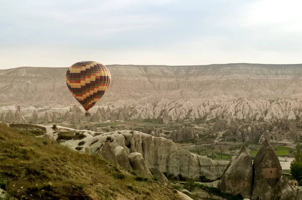 Scenic view of hot air balloon flying over stone formations in valley of Cappadocia, Turkey — Stock Photo