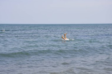 Boğulan bir adam. Okyanus ayaklarından çıkıyor. Denizde yüzmenin keyfi. Suya sıçrama