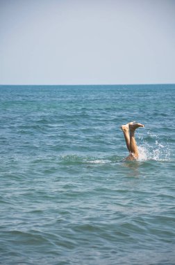 Boğulan bir adam. Okyanus ayaklarından çıkıyor. Denizde yüzmekeyfi