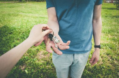 Anahtarlı bir ev satma konsepti. Adam yeni bir ev alıyor.