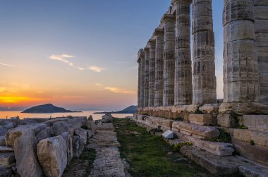 Sounion, Attika / Yunanistan: renkli günbatımında Cape Sounion ve Poseidon Tapınağı Patroklos Adası arka planda görünür ile yıkıntıları.