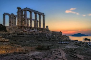 Sounion, Attika / Yunanistan: renkli günbatımında Cape Sounion ve Poseidon Tapınağı Patroklos Adası arka planda görünür ile yıkıntıları.