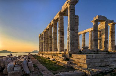Sounion, Attika / Yunanistan: renkli günbatımında Cape Sounion ve Poseidon Tapınağı Patroklos Adası arka planda görünür ile yıkıntıları.