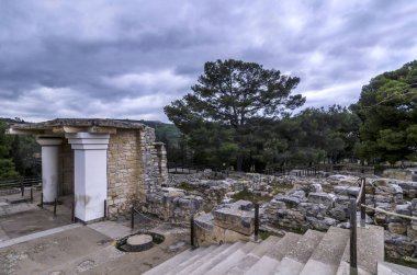 Knossos Palace, Girit / Yunanistan. Güney Propylaeum Kandiye'deki Knossos arkeoloji kalanında iki fresk ile bina restore edin. Gün batımı, bulutlu gökyüzü