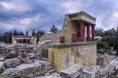 Knossos Palace, Girit / Yunanistan. Knossos arkeolojik sitesinde şarj boğa fresk ile Kuzey Girişi restore. Arka planda Kuzey Lustral Havzası oda. Gün batımı, bulutlu gökyüzü