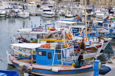 Kandiye, Girit Adası / Yunanistan. Renkli geleneksel balıkçı tekneleri Kandiye şehrindeki eski Venedik limanına demirledi. Balıkçılar sıkı çalışma başka bir gün için hazırlanıyor.