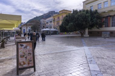Nafplio, Mora / Yunanistan. Eski geleneksel evler, binalar, kafeler, restoranlar ile merkezi döşeli kare pitoresk görünümü. Tepenin üstündeki tarihi Palamidi kalesi