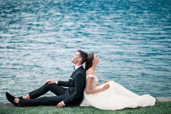 Casamento casal beijando no fundo de um lago e montanhas — Fotografia de Stock