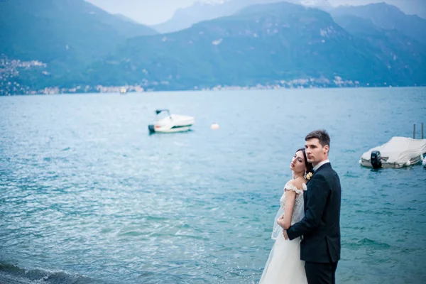 Casamento casal beijando no fundo de um lago e montanhas — Fotografia de Stock