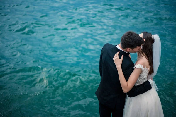 湖と曇天山中の背景にキス結婚式のカップル — ストック写真