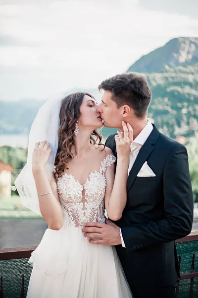 Casamento casal beijando no fundo das montanhas — Fotografia de Stock