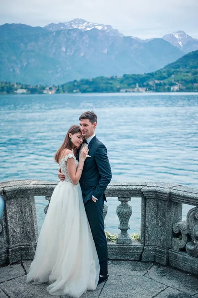 婚礼夫妇拥抱湖泊和山脉的背景 — 图库照片