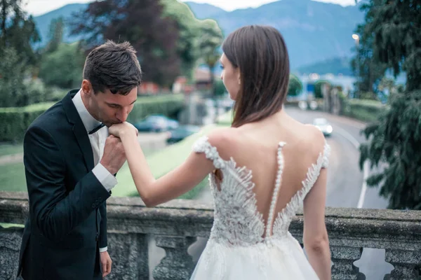 Casamento casal beijando no fundo de um lago e montanhas — Fotografia de Stock