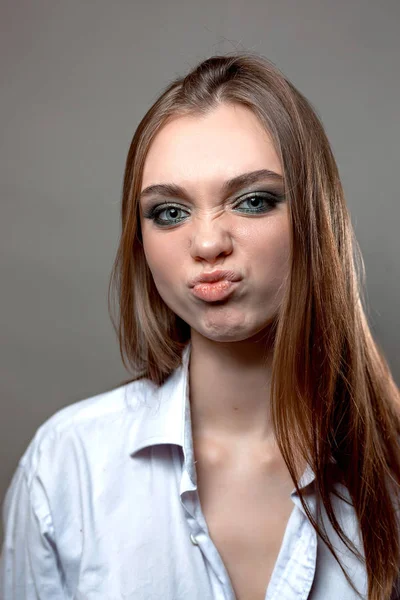 Chica con una cara disgustada en una camisa — Foto de Stock