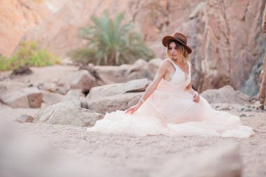 güzel gelin bir taş bir kanyon oturur ve onu elbise düzeltiyor