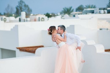 Bir lüks tatil düğün sonra yeni evliler. Romantik gelin ve damat otel çatısında öp. Balayı. Tropik ülke. Düğün çifti.