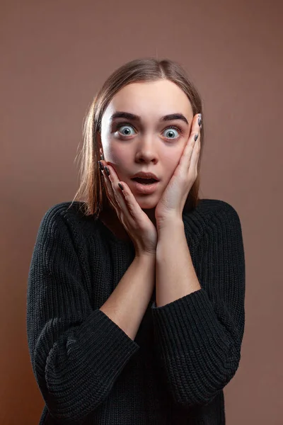 Bella giovane donna con un'espressione di paura, su uno sfondo beige — Foto Stock