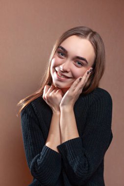 Siyah kazaklı bir gülümsemeyle güzel genç kadın