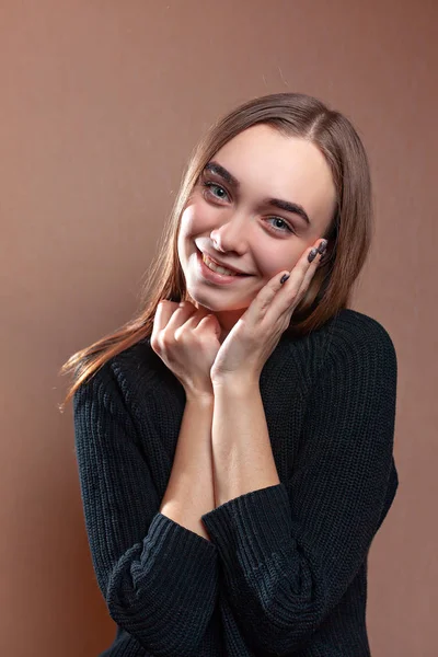 Siyah kazaklı bir gülümsemeyle güzel genç kadın