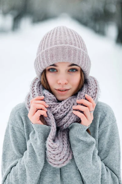 A portrait of a cute girl child who tries the snow with her tongue in a heavy snowfall in forest. — Stock Photo, Image