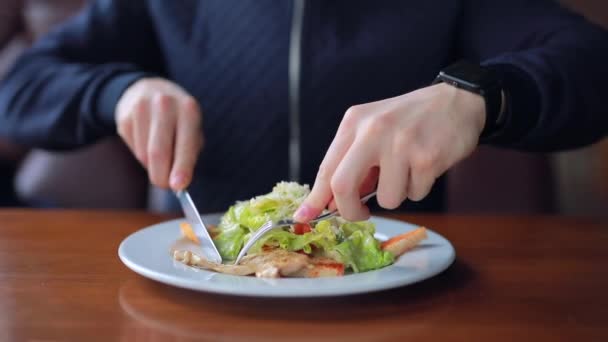Молодой человек ест вкусный куриный салат — стоковое видео