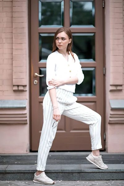 Hermosa mujer joven se para en pantalones y blusa concebida — Foto de Stock