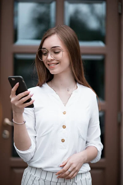 Bir telefon ile bir bluz güzel genç kadın — Stok fotoğraf