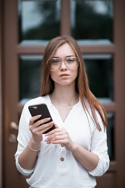 Hermosa joven en una blusa con un teléfono —  Fotos de Stock