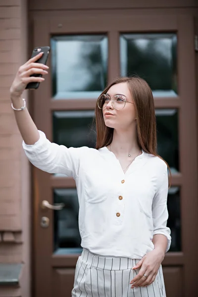 Bir telefon ile bir bluz güzel genç kadın — Stok fotoğraf