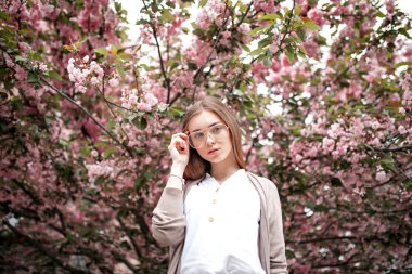 kiraz çiçekleri yakınında bir bluz ve gözlük güzel genç mutlu kadın