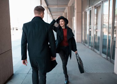 Siyahlı genç adam siyahlı genç bir kadına doğru gidiyor.