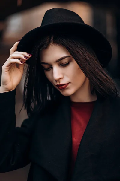 Bela jovem mulher em um casaco preto e chapéu — Fotografia de Stock