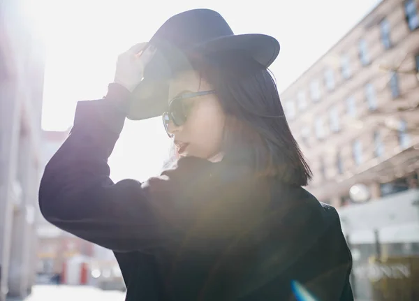 Bela jovem mulher em um chapéu preto e óculos — Fotografia de Stock