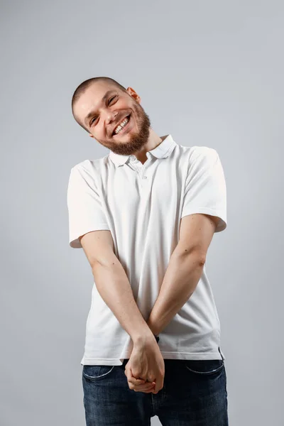 Retrato Belo Jovem Tímido Uma Camiseta Branca Fundo Cinza Isolado — Fotografia de Stock