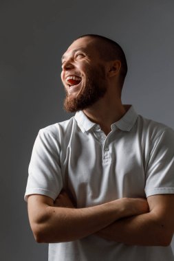 Gri arka planda dikkatlice bakan yakışıklı, mutlu bir gencin portresi. İzole. metin için yer