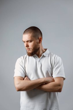 Gri arka planda üzgün görünen yakışıklı bir gencin portresi. İzole. metin için yer