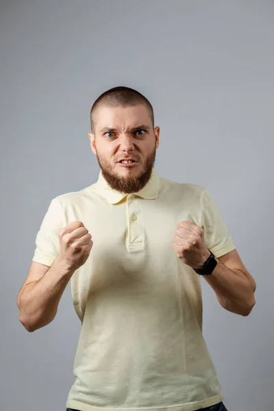 Porträtt Ung Arg Man Gul Shirt Med Knytnävar Grå Bakgrund — Stockfoto