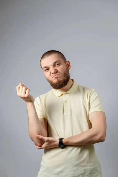 Retrato Jovem Homem Descontente Uma Camiseta Amarela Fundo Cinza Isolado — Fotografia de Stock