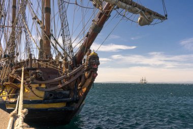 1703 üzerinden eski Yelkenli arka planda bekleyen başka bir gemi ile sahilinde demirli