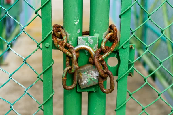 古くて錆びた南京錠フェンスの小さな橋へのアクセス制限で緑のドアにチェーン — ストック写真
