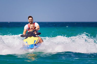 mutlu, heyecanlı bir aile, baba ve oğul eğleniyor jet ski yaz tatili