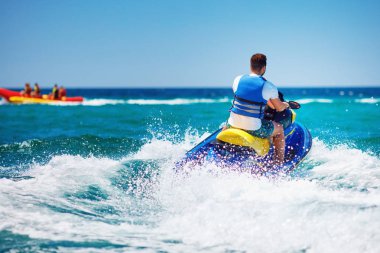 dalga jet ski üzerinde yaz tatili koşan genç yetişkin adam