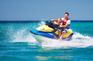 mutlu, heyecanlı bir aile, baba ve oğul eğleniyor jet ski yaz tatili