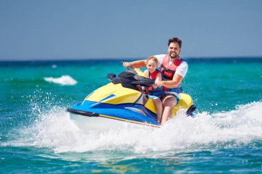 mutlu, heyecanlı bir aile, baba ve oğul eğleniyor jet ski yaz tatili